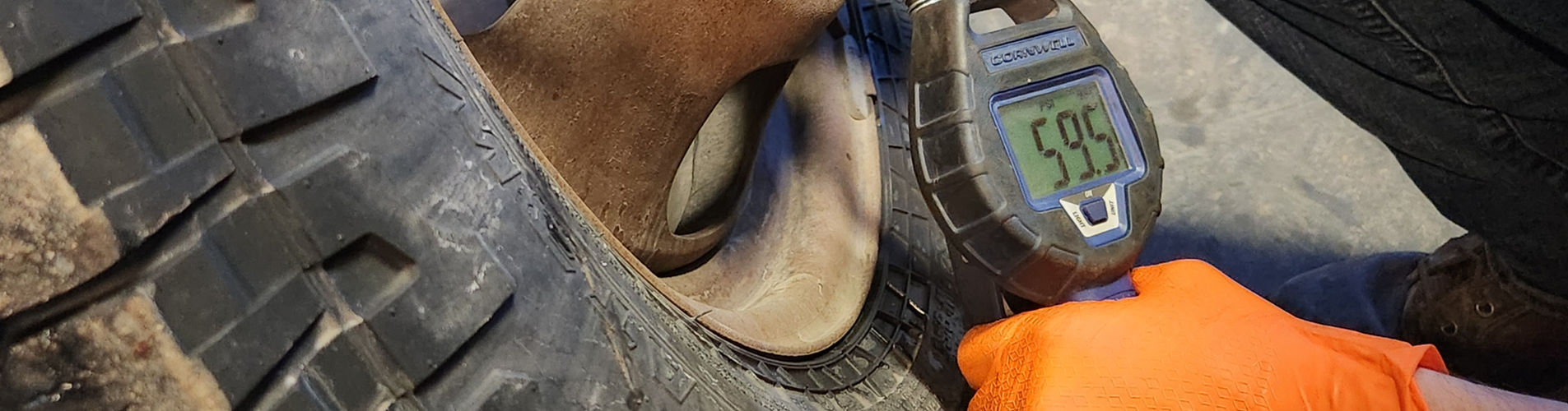 mechanic measuring tire pressure